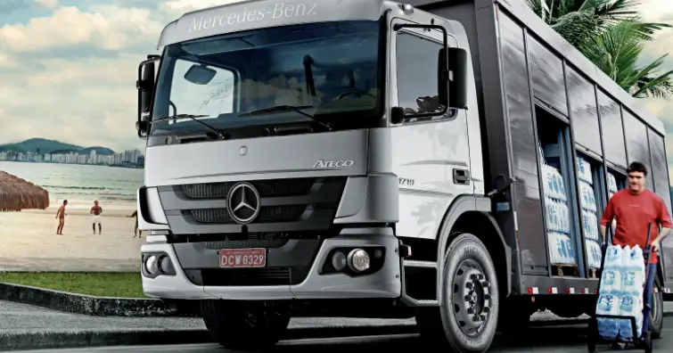 Caminhao Mercedes Benz Atego 1719 na cor prata com carregamento de agua e um homem descarregando as garrafas com um carrinho